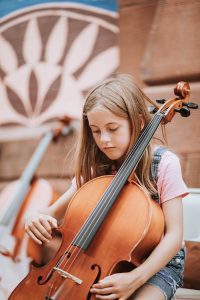 A young girl tries out a cello from the Quad City Symphony at the June 8 "Paint the Town" event at River Music Experience, Davenport.