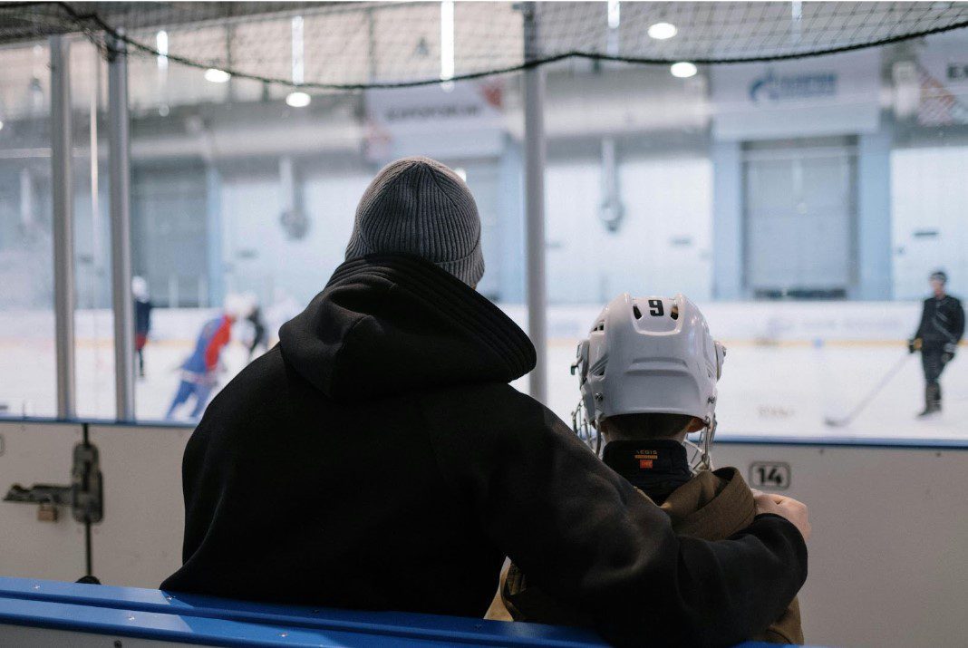 Coach mentoring young hockey player rinkside - QuadCities.com