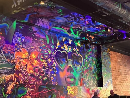 Heidi Sallows' painting of a face with heart-shaped glasses reflects the restaurant name -- Corazon is Spanish for "heart" (photo by Jonathan Turner).