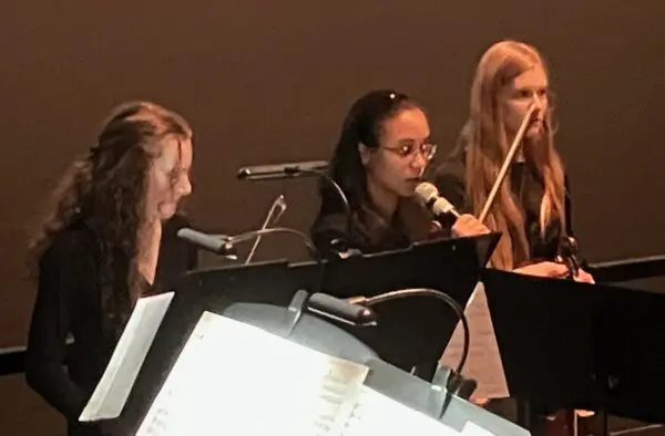 QC Youth Symphony Orchestra members Elise Brock, left, Haven O'Brian and Bethany Priaulx speaking during the "Violins of Hope" program at the Putnam Giant Screen Theater (photo by Jonathan Turner).