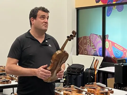Violins of Hope project leader Avshi Weinstein, with the historic instruments at the Putnam Museum Feb. 16, 2026 (photo by Jonathan Turner).