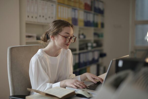 A professional woman concentrating on her laptop at a modern office desk.