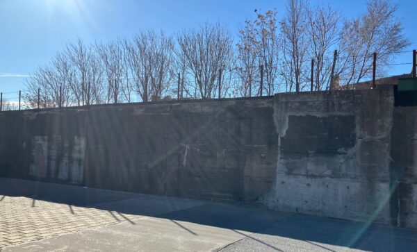 Quad City Arts, Friends of MLK and Downtown Davenport Partnership are seeking qualified artists to paint a new mural on this wall on the train bridge on the southeast corner of Brady and 5th streets (photo by Jonathan Turner).